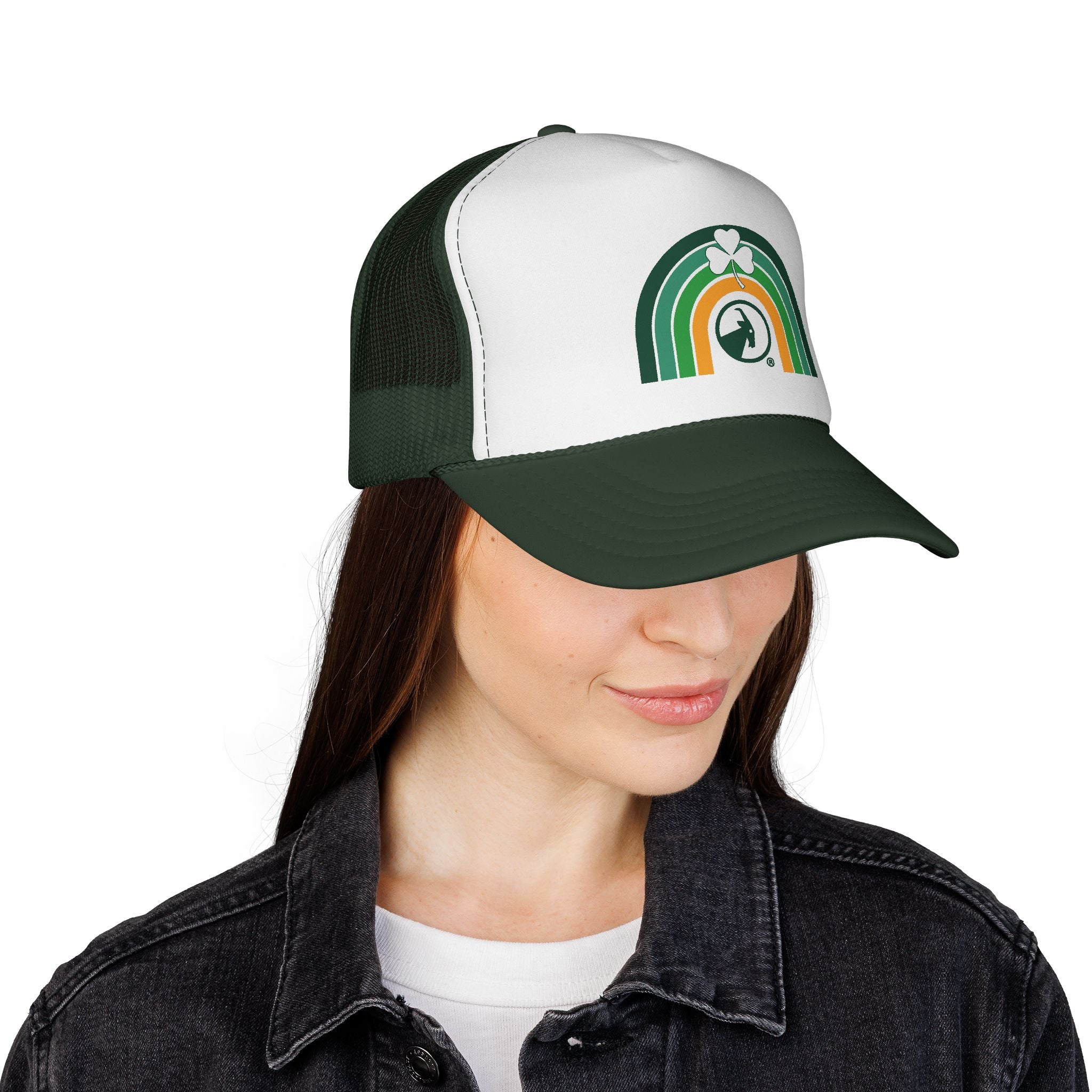 Woman wearing a green and white cap with rainbow and clover, smiling on a white background