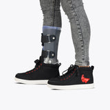 Person wearing gray jeans and an orthopedic brace partially inside Black/Red Light Ups BILLY Classic D|R High sneakers by BILLY Footwear; the shoes are AFO-friendly with removable insoles for comfort.