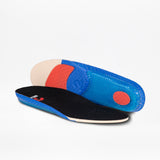 A pair of colorful insoles for the Men's Black Suede BILLY Comfort Chukka by BILLY Footwear, one lying flat and one propped up to show the blue, red, and beige textured underside with a black top and blue trim, on a white background.