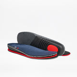A pair of Men's Navy Suede BILLY Comfort Plush insoles by BILLY Footwear, featuring navy fabric tops, red sides, and black textured bottoms, are shown on a white background—one flat, one propped to display the sole.