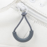 Charcoal loop zipper pull attached to a white sneaker
