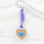 Heart-shaped zipper pull with colorful design on a white shoe 