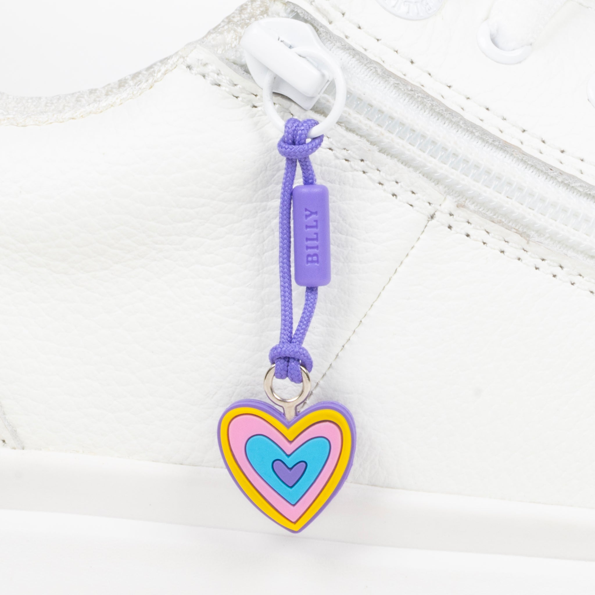 Heart-shaped zipper pull with colorful design on a white shoe 