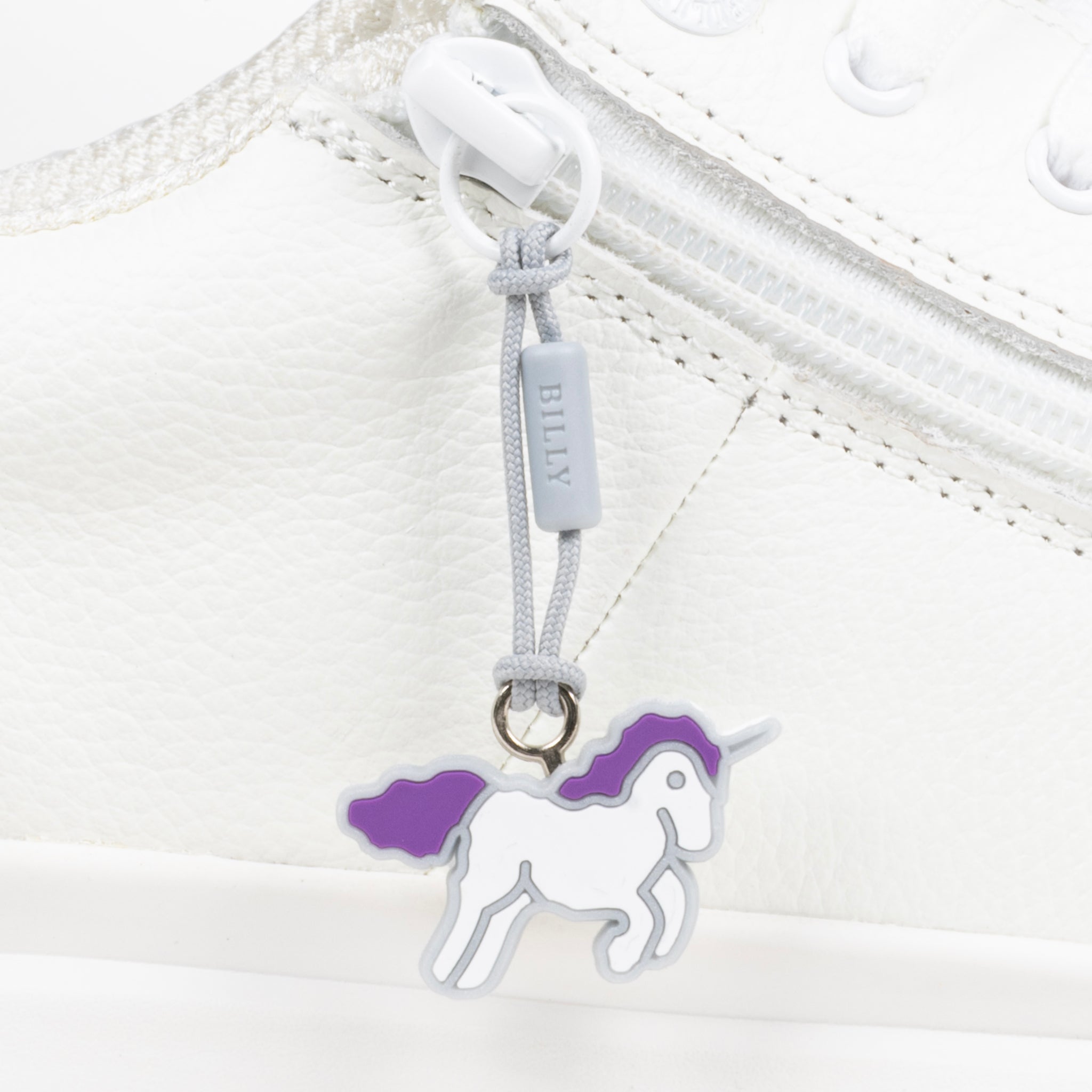 White shoe with a unicorn zipper pull on a white background