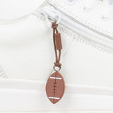 Brown football-shaped zipper pull attached to a white sneaker
