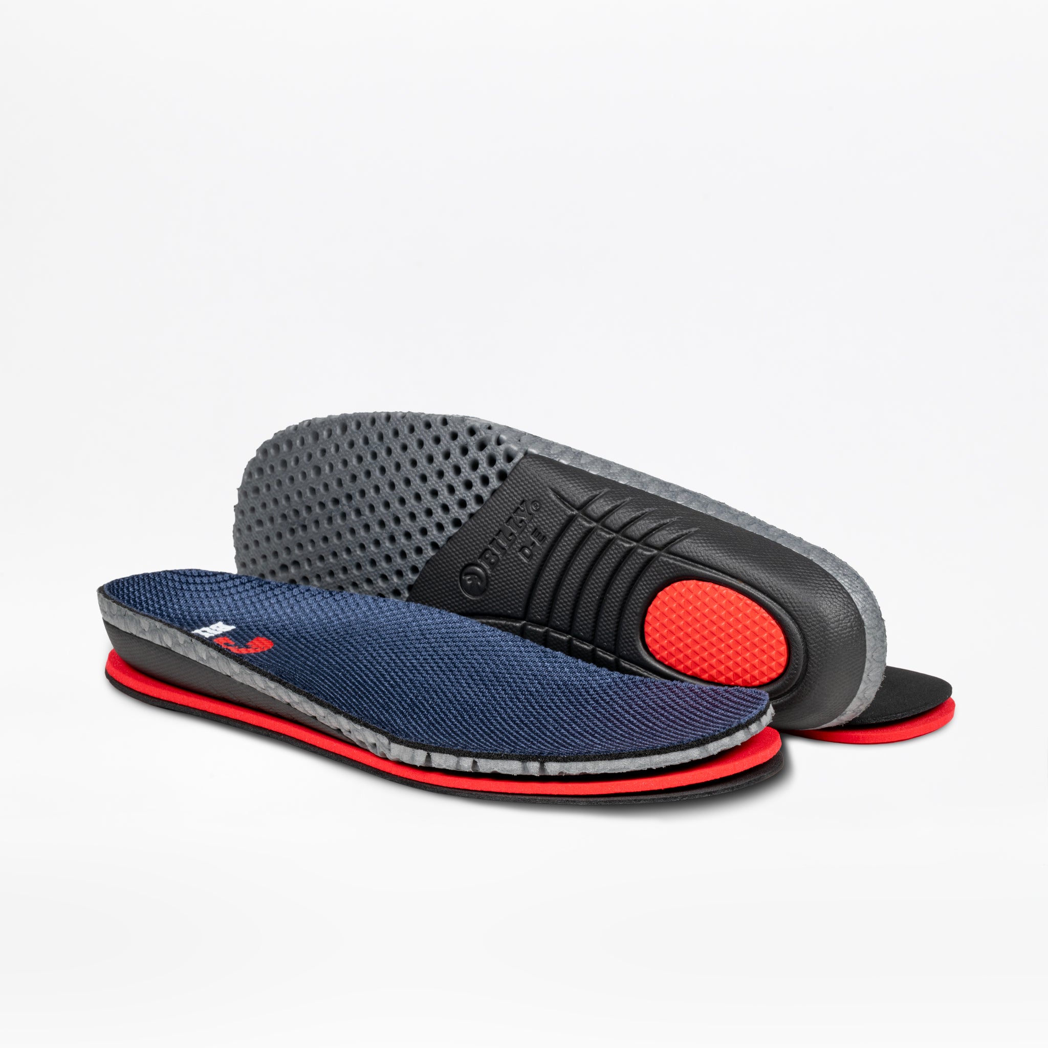 The BILLY Footwear Women's White/Navy Limitless 253 features orthopedic-grade insoles with navy blue tops, grey sides, and red heel cushioning—perfect for easy-on, easy-off shoes. One insole stands to display its textured grey underside, the other lies flat.
