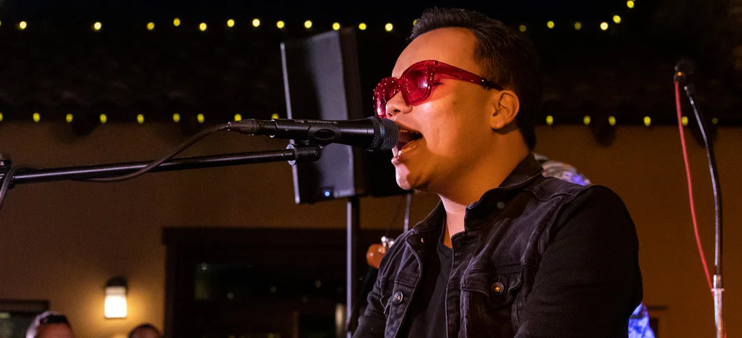 Image of Kodi performing on stage singing into mic